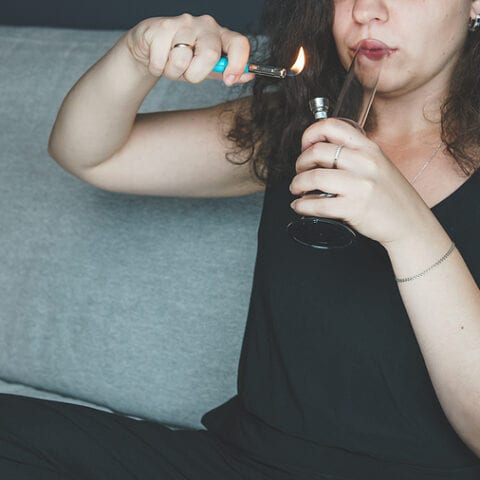 Young person smoking marijuana with bong
