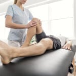 Patient at the physiotherapy doing physical exercises with his therapist