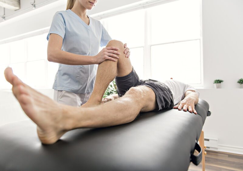 Patient at the physiotherapy doing physical exercises with his therapist