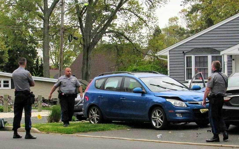 Woman drops cigarette while driving, strikes two people, dog, parked cars and mailbox