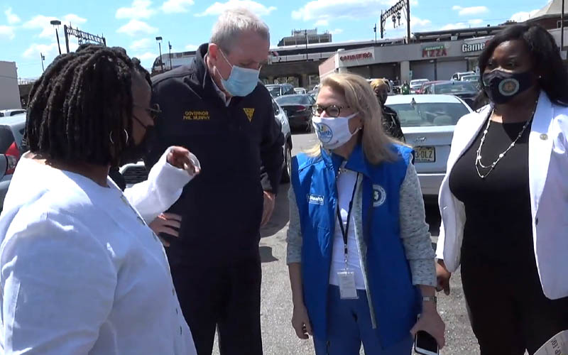 Masked up Murphy greets crowd with "Mask Up" signs day after CDC drops mask mandate for the vaccinated