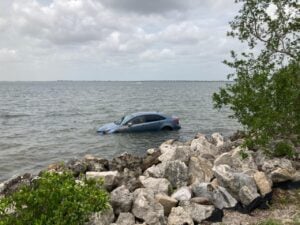 Tide swallows car parked on protected beach along Courtney Campbell Causeway