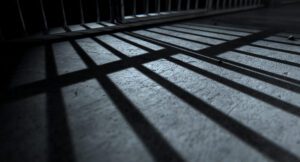 Bars from a prison jail cast a shadow on the floro.
