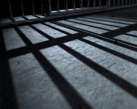 Bars from a prison jail cast a shadow on the floro.