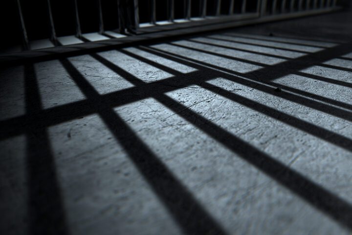Bars from a prison jail cast a shadow on the floro.