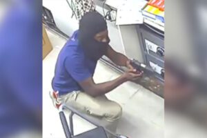 Man wanted after pointing gun at female convenience store worker