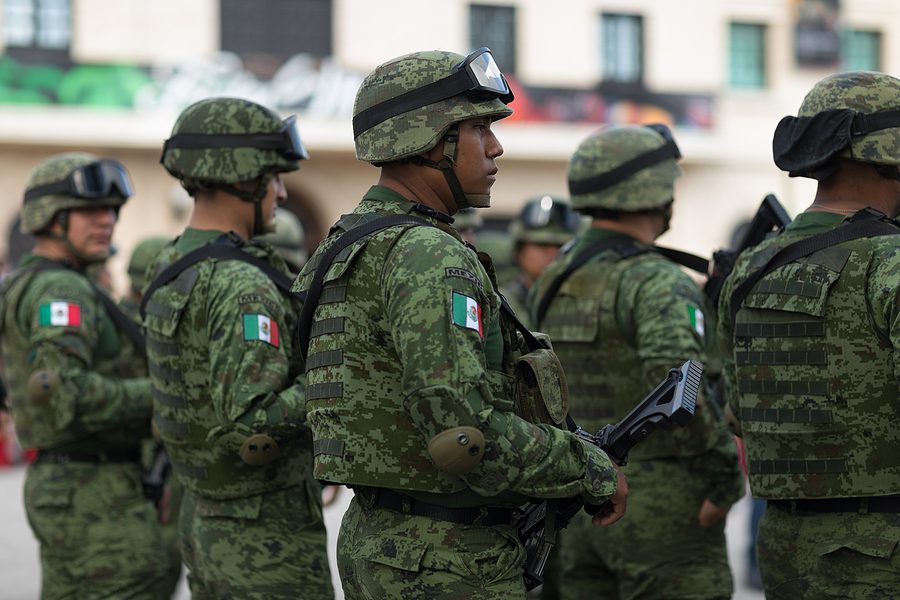 Mexican troops in riot gear attempting to stop immigrants heading to U.S.