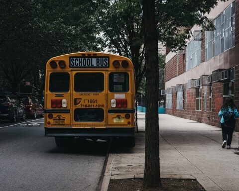 New York, USA - May 30, 2018: Yellow school bus parked on a side of the road in New York.