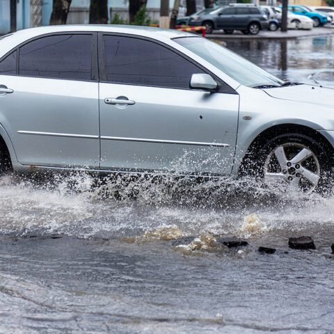 Car driving through flooded road.
