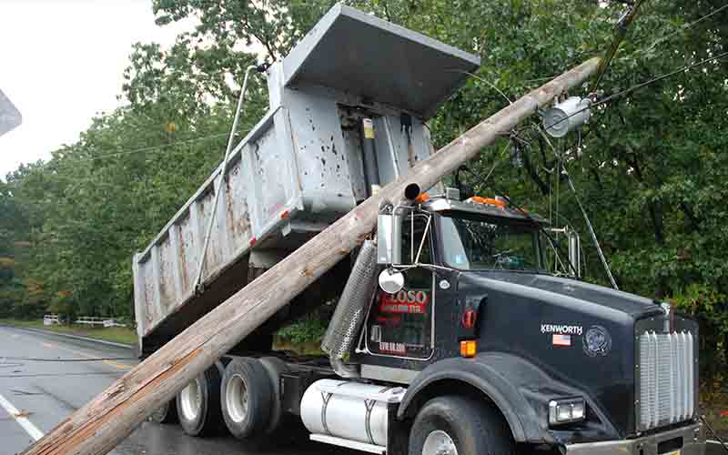 Dump truck with elevated rear box severs telephone pole