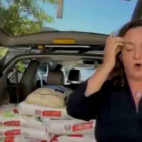 Congresswoman stands near her gas-powered minivan while using candy, rice to prove oil companies are bad - photo licensed by shore news network.