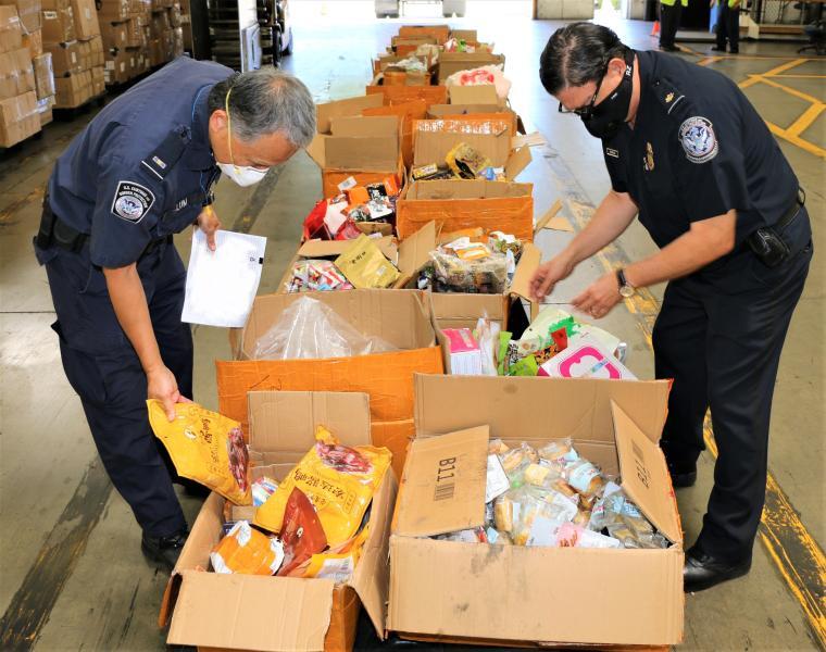 Animal Food Contraband from China Remains at Record Levels at LA/LB Seaport Two Agriculture Specialists Inspect a Food Contraband Shipment