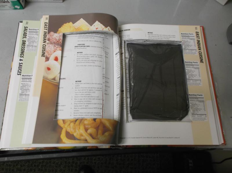 Memphis Seizes a Cocaine Cookbook from Trinidad & Tobago Inside of cookbook, with it opened to show cut out area with dark package of cocaine placed inside
