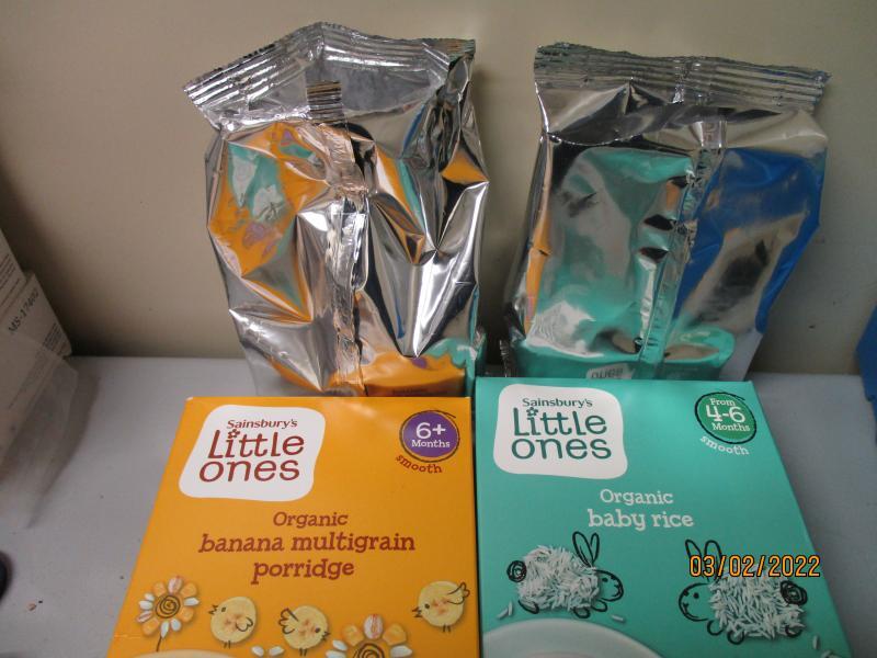 Organic Baby Porridge, Rice and Special K in Shipment Two boxes, one of porridge the other of rice, with interior aluminum bag laid out in front of them