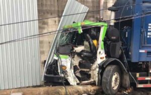 Garbage truck driver extricated by fdny after colling with wall, telephone pole