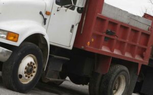 Driver injured after dump truck full of sand overturned in egg harbor