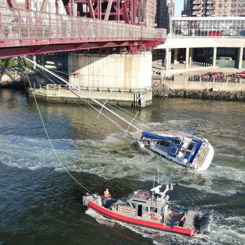 Sailboat gets stuck under roosevelt island bridge in queens - photo licensed by shore news network.