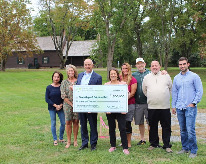 Commissioner Deputy Director Melonie Marano presented Bedminster Mayor Lawrence Jacobs with a check for $300,000 from the County’s Recreational Open Space Fund to build a community garden at River Road Park alongside the historic Jacobus Vanderveer House.