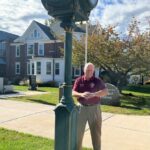 Mayor Mo Hill is checking the time on the newly repaired clock at Town Hall.