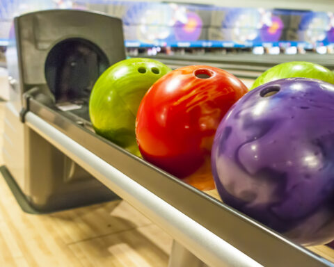 Colored Bowling balls in a return rack