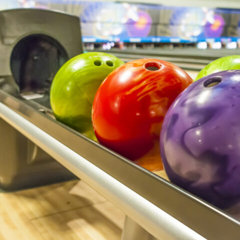 Colored bowling balls in a return rack