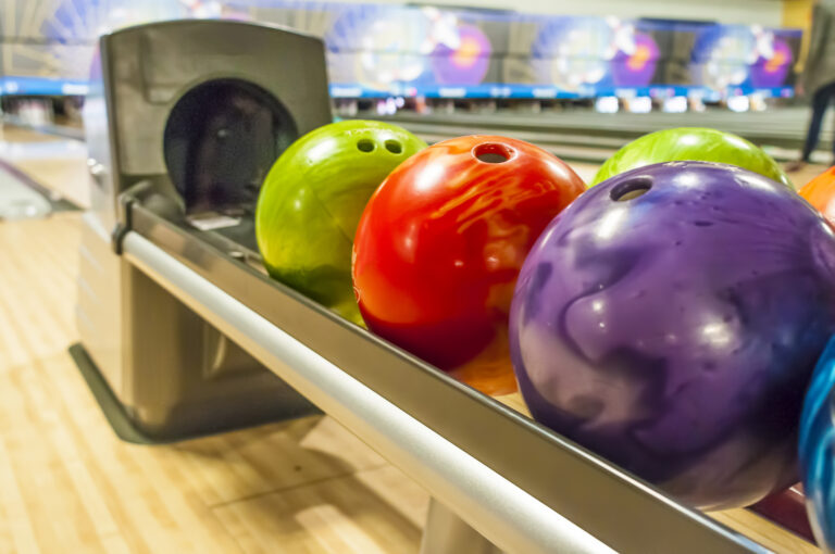 Colored bowling balls in a return rack