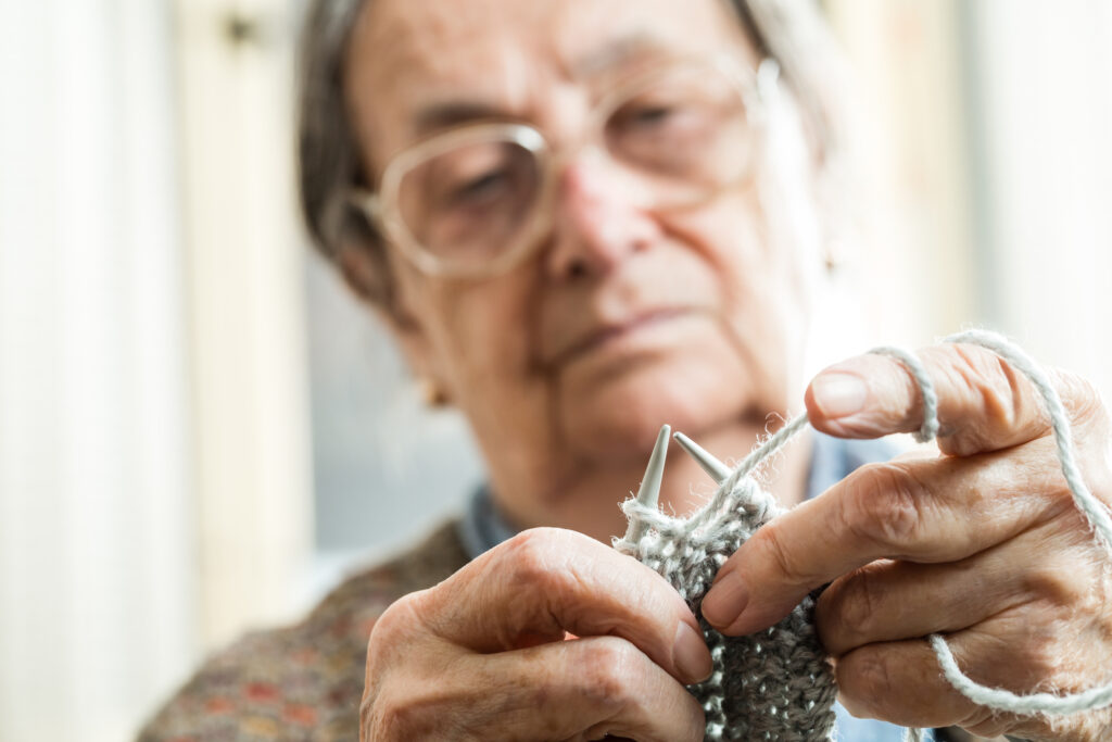 Close up of the hands of an elderly woman knitting, could possibly be a deadly weapon under NJ law.