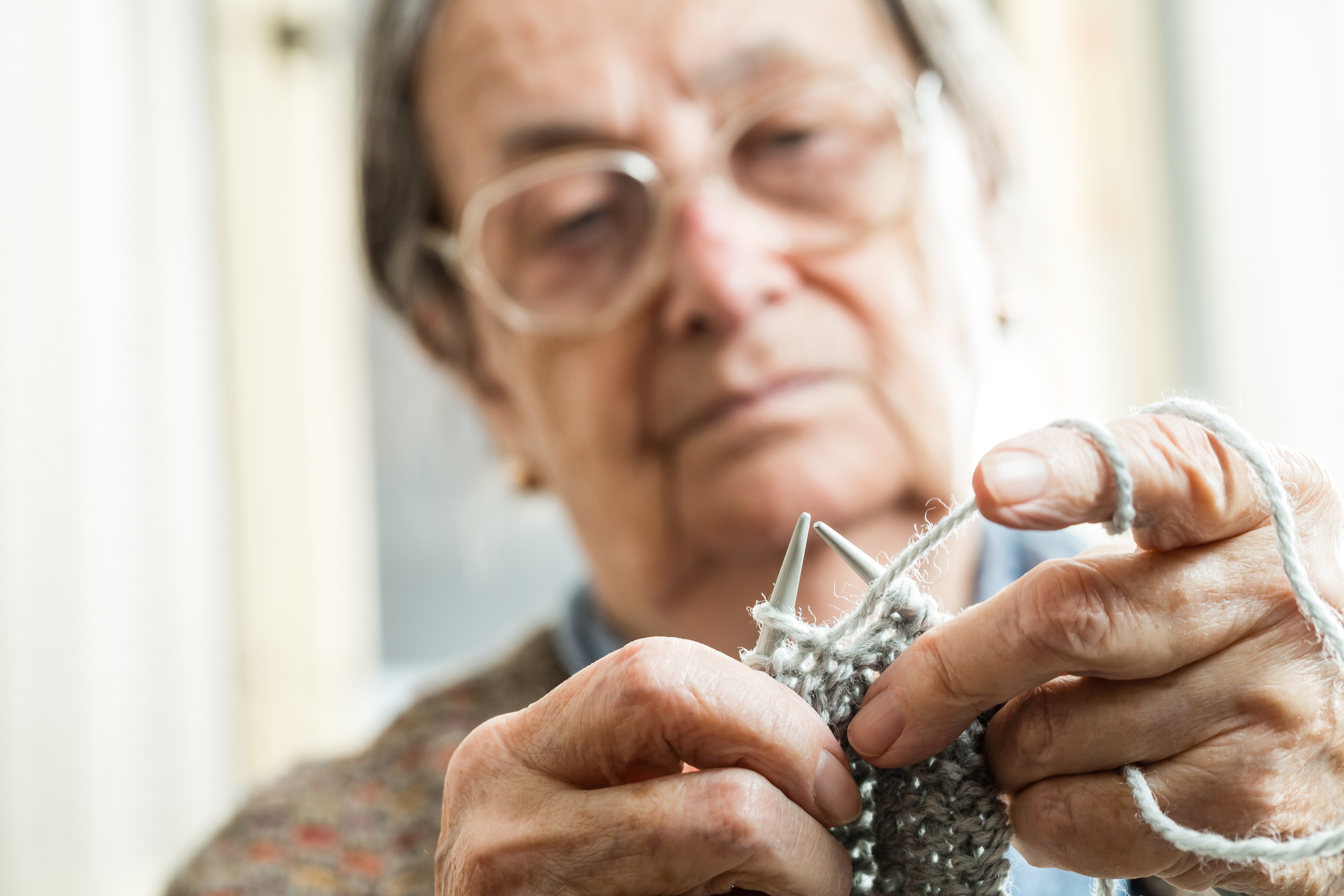 Close up of the hands of an elderly woman knitting, could possibly be a deadly weapon under NJ law.