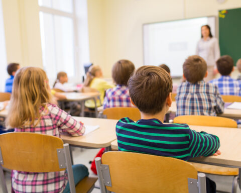 Group of school kids and teacher in classroom