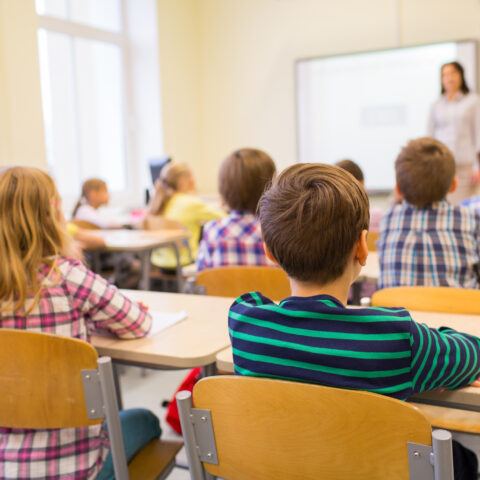 Group of school kids and teacher in classroom