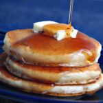Syrup pouring onto pancakes - HD Connely.