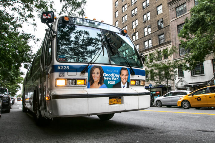 An MTA bus stands idle with lights flashing in the street in Manhattan.