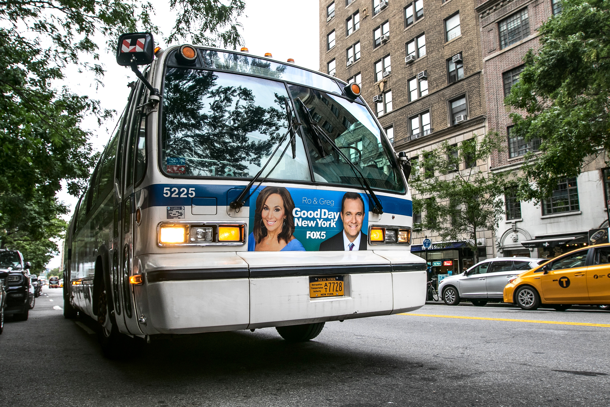 An MTA bus stands idle with lights flashing in the street in Manhattan.