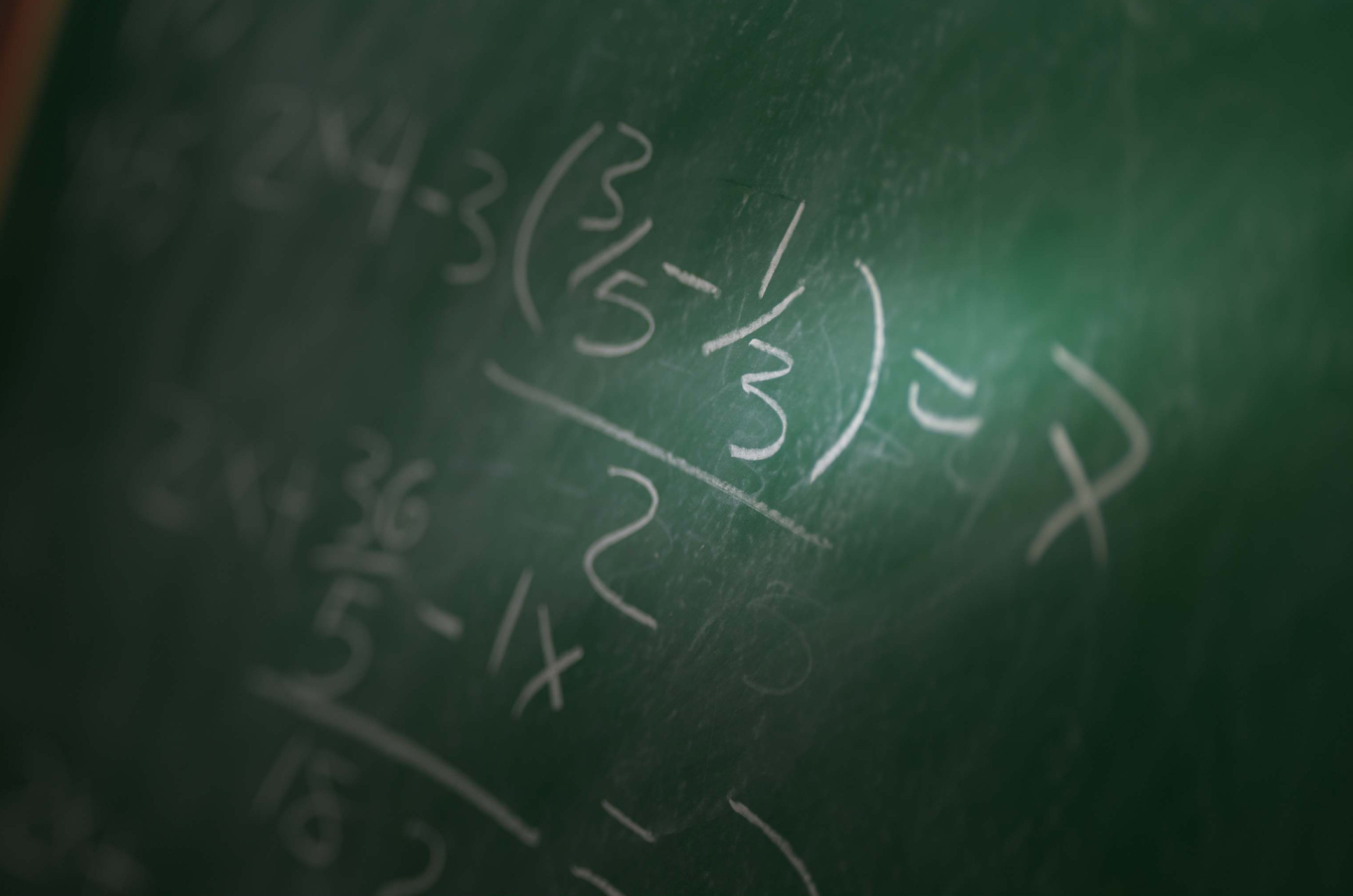 Math problem writing on a chalk board