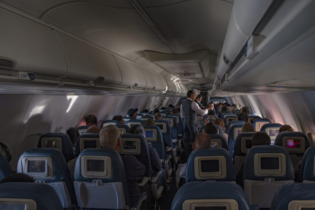 : Flight attendants doing the drink and snack service on the domestic flight. flight service,airplane cabin,airplane,drink,