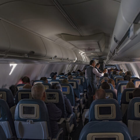 : flight attendants doing the drink and snack service on the domestic flight. Flight service,airplane cabin,airplane,drink,