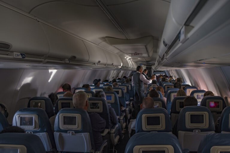 : flight attendants doing the drink and snack service on the domestic flight. Flight service,airplane cabin,airplane,drink,