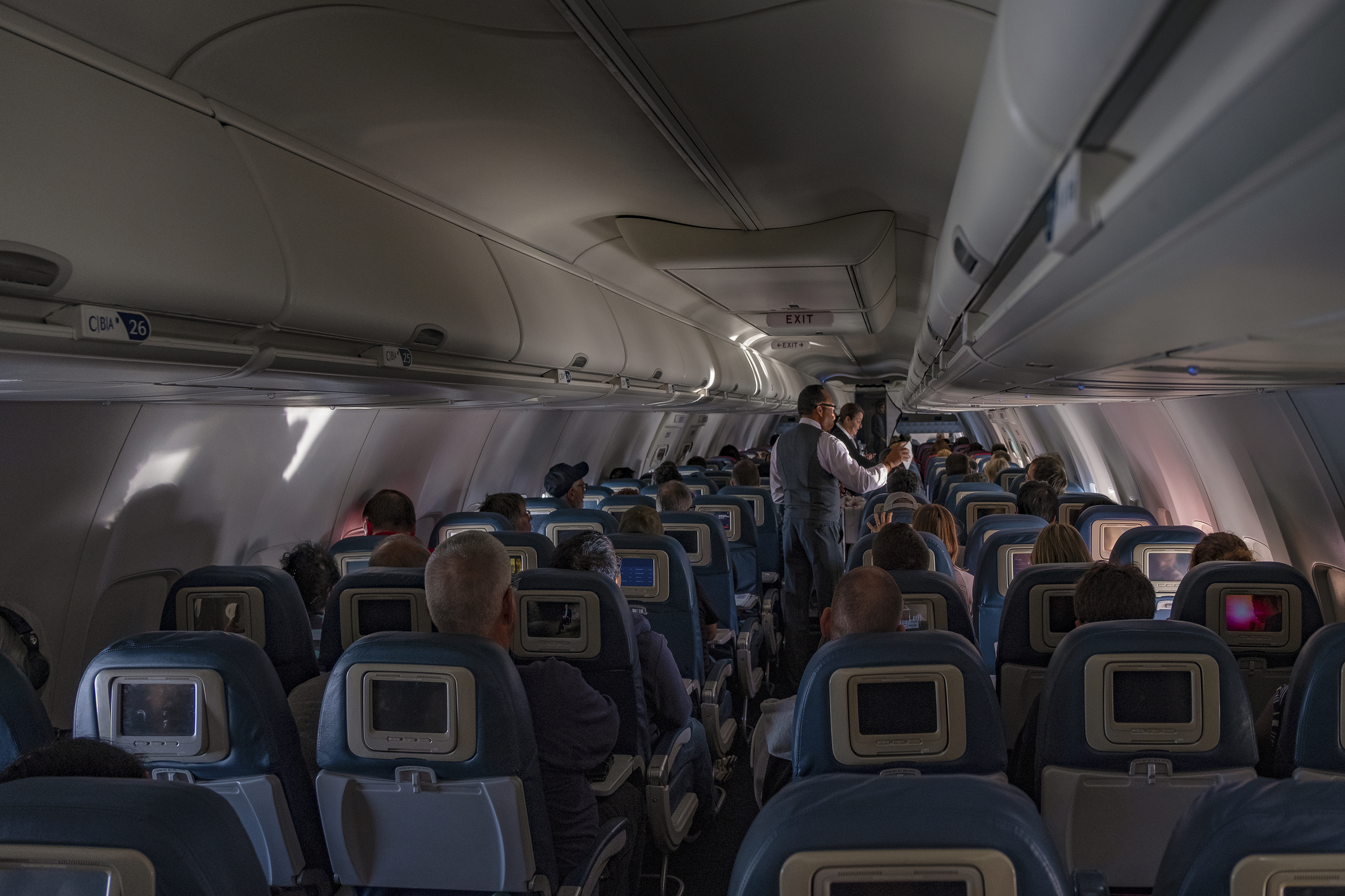: Flight attendants doing the drink and snack service on the domestic flight. flight service,airplane cabin,airplane,drink,