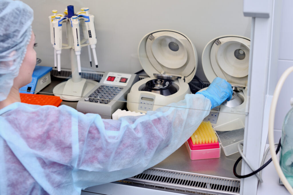 Dna test in the lab. a laboratory technician with a dispenser in his hands is conducting dna analysis in a sterile laboratory