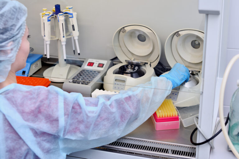 Dna test in the lab. A laboratory technician with a dispenser in his hands is conducting dna analysis in a sterile laboratory
