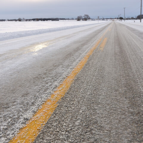 Close up of slippery icy slushy pavement road in winter