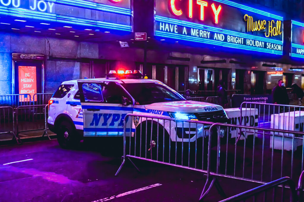 New York, NY - May 10, 2022: Parked police squad car with sirens flashing, by Radio Music City Hall.