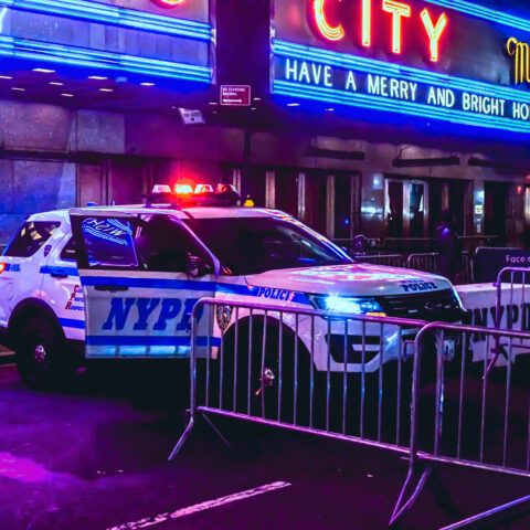 New york, ny - may 10, 2022: parked police squad car with sirens flashing, by radio music city hall.