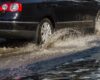 Car driving through flooded road.