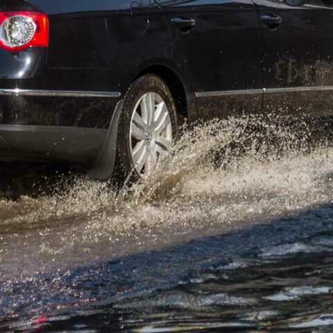 Car driving through flooded road.