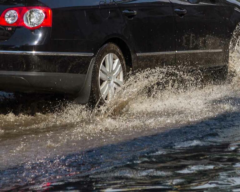 Car driving through flooded road.
