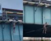 Naked man hanging from elevated train tracks in the Bronx caught on video