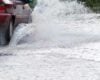 Car driving through flooded street - file photo by janeh