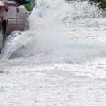 Car driving through flooded street - File Photo by JaneH