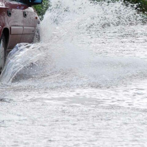 Car driving through flooded street - file photo by janeh